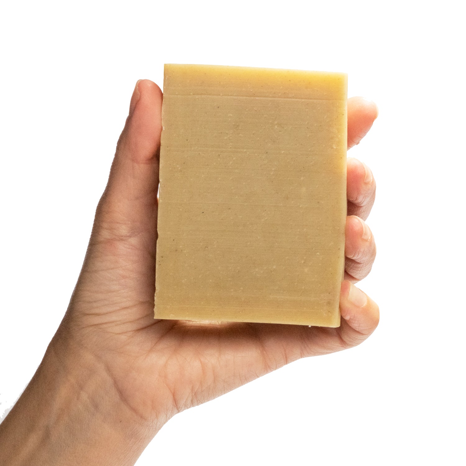 A naked bar of Face Mate Teatree essential oil and rhassoul clay organic bar soap from ground Soap in a hand.  